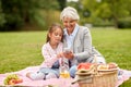 Grandmother and granddaughter with cell at park Royalty Free Stock Photo