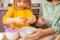 Grandmother and granddaughter cook in kitchen in middle, family pastime