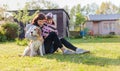 Grandmother with granddaughter and dog playing on the sunbathing lawn Royalty Free Stock Photo