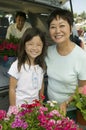 Grandmother and granddaughter with flowers by back of SUV portrait