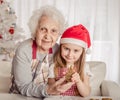 Grandmother with granddaughter holding baked cookie