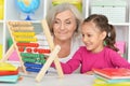 Grandmother and granddaughter learning to use abacus