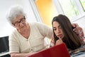 Grandmother and granddaughter looking at laptop computer together at home Royalty Free Stock Photo