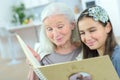 Grandmother and granddaughter looking at photograph album