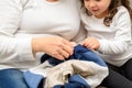 Grandmother And Granddaughter Mending Clothes.