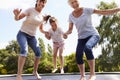 Grandmother, Granddaughter And Mother Bouncing On Trampoline Royalty Free Stock Photo