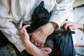 Grandmother and granddaughter pet a black cat sitting on her lap Royalty Free Stock Photo