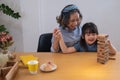 Grandmother and granddaughter play games. Blockwood Puzzle To develop skills for granddaughter and as a holiday activity