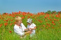 Grandmother and granddaughter play in poppy field