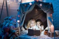 Grandmother and granddaughter are reading book in blanket house at night at home. Royalty Free Stock Photo