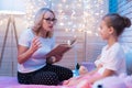 Grandmother and granddaughter are reading children`s book at night at home. Royalty Free Stock Photo