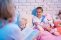 Grandmother and granddaughter are reading fairy tales book at night at home. Royalty Free Stock Photo