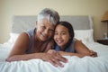 Grandmother and granddaughter relaxing on bed in bed room Royalty Free Stock Photo