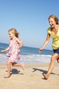 Grandmother And Granddaughter Running Along Beach Royalty Free Stock Photo