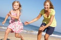 Grandmother And Granddaughter Running Along Beach Royalty Free Stock Photo