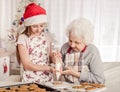 Grandmother with granddaughter decorate cookies Royalty Free Stock Photo