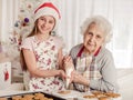 Grandmother with granddaughter decorate cookies Royalty Free Stock Photo