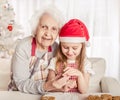 Grandmother with granddaughter holding baked cookie