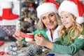 Grandmother and granddaughter in Santa hats making New Year& x27;s decorations