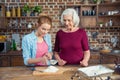 Grandmother and granddaughter sifting flour