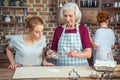 Grandmother and granddaughter sifting flour