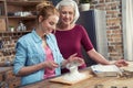 Grandmother and granddaughter sifting flour