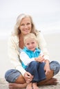 Grandmother And Granddaughter Sitting On Beach Royalty Free Stock Photo