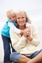 Grandmother And Granddaughter Sitting On Beach Royalty Free Stock Photo