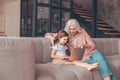 Grandmother and granddaughter sitting on the couch and using laptop at home Royalty Free Stock Photo