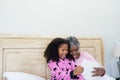 Grandmother and granddaughter taking selfie on digital tablet in bed room Royalty Free Stock Photo