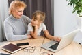 Grandmother with granddaughter use laptop learn counting together home