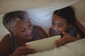 Grandmother and granddaughter using digital tablet in bed room Royalty Free Stock Photo