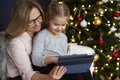 Grandmother with granddaughter using tablet in Christmas time Royalty Free Stock Photo