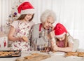 Grandmother with granddaughters soak cream decorating cookies with cream Royalty Free Stock Photo