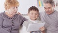 Grandmother , grandfather and grandson looking at digital tablet while relaxing on the sofa Royalty Free Stock Photo