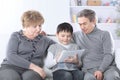 Grandmother , grandfather and grandson looking at digital tablet while relaxing on the sofa Royalty Free Stock Photo