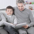 Grandmother and grandfather reading book to his grandchild.the concept of education Royalty Free Stock Photo