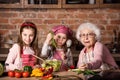 Grandmother and grandkids cooking salad Royalty Free Stock Photo