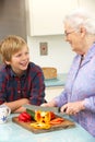 Grandmother and grandson preparing food in kitchen
