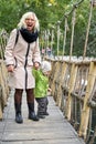 Grandmother and grandson walk on a rope suspension bridge Royalty Free Stock Photo