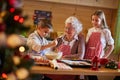 Grandmother helping grandchildren preparing Christmas cookies Royalty Free Stock Photo