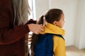 Grandmother helping granddaughter to get ready to leave home for school. Royalty Free Stock Photo