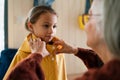 Grandmother helping granddaughter to get ready to leave home for school. Royalty Free Stock Photo