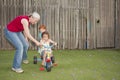 Grandmother helping kids ride trike