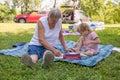 Grandmother with her grandaughter casually sitting on a blanket reading and talking in a park. Royalty Free Stock Photo