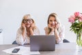 Grandmother with her granddaughter sitting at the table with laptop Royalty Free Stock Photo