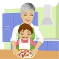 Grandmother with her grandson preparing delicious pizza together in kitchen Royalty Free Stock Photo