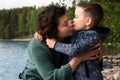 Grandmother and her grandson sitting and hugging hear the sea. Happy kissing family. Royalty Free Stock Photo