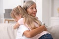Happy grandmother hugging her granddaughter at home Royalty Free Stock Photo