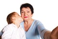 Grandmother hugging her grandson on a white background and making selfie Royalty Free Stock Photo